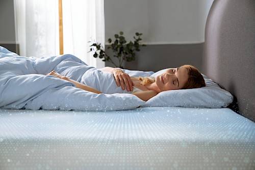 Woman lying on a cooling Tempur mattress.