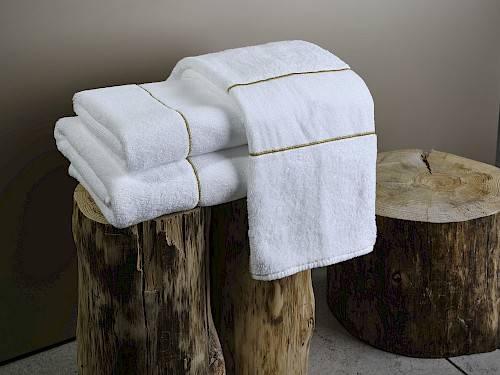 Empilement de serviettes de bain blanches sur une souche d'arbre